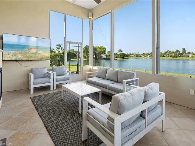 a living room with furniture and a floor to ceiling window