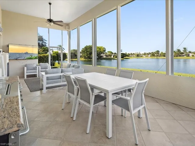 a dining room with furniture water view and a floor to ceiling window