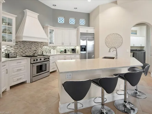 a kitchen with a table chairs sink and cabinets