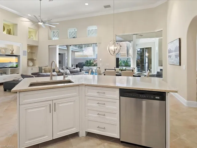 a kitchen with white cabinets and chandelier