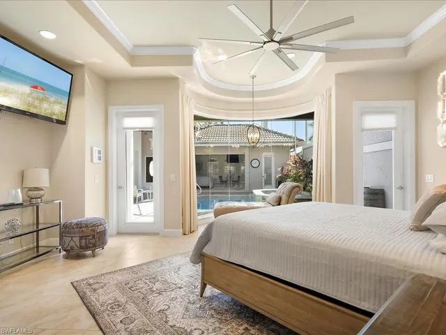 a bedroom with a large bed and a chandelier