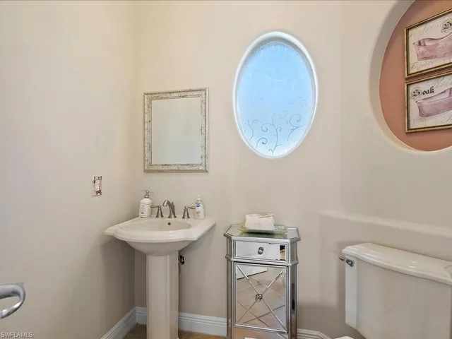 a bathroom with a toilet a sink and a mirror