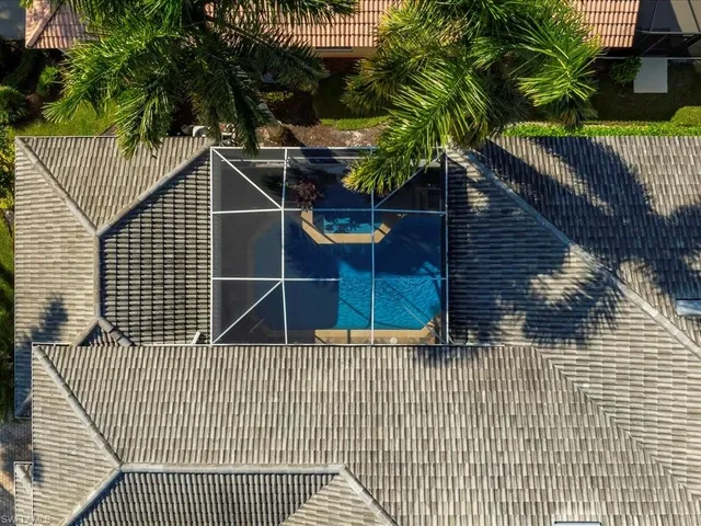 an aerial view of ocean and residential houses with outdoor space