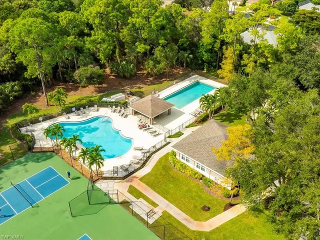 a view of a swimming pool with lawn chairs and plants