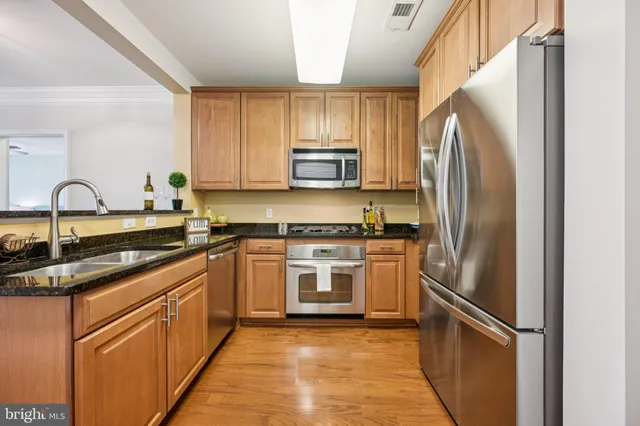 a kitchen with stainless steel appliances granite countertop a sink and cabinets