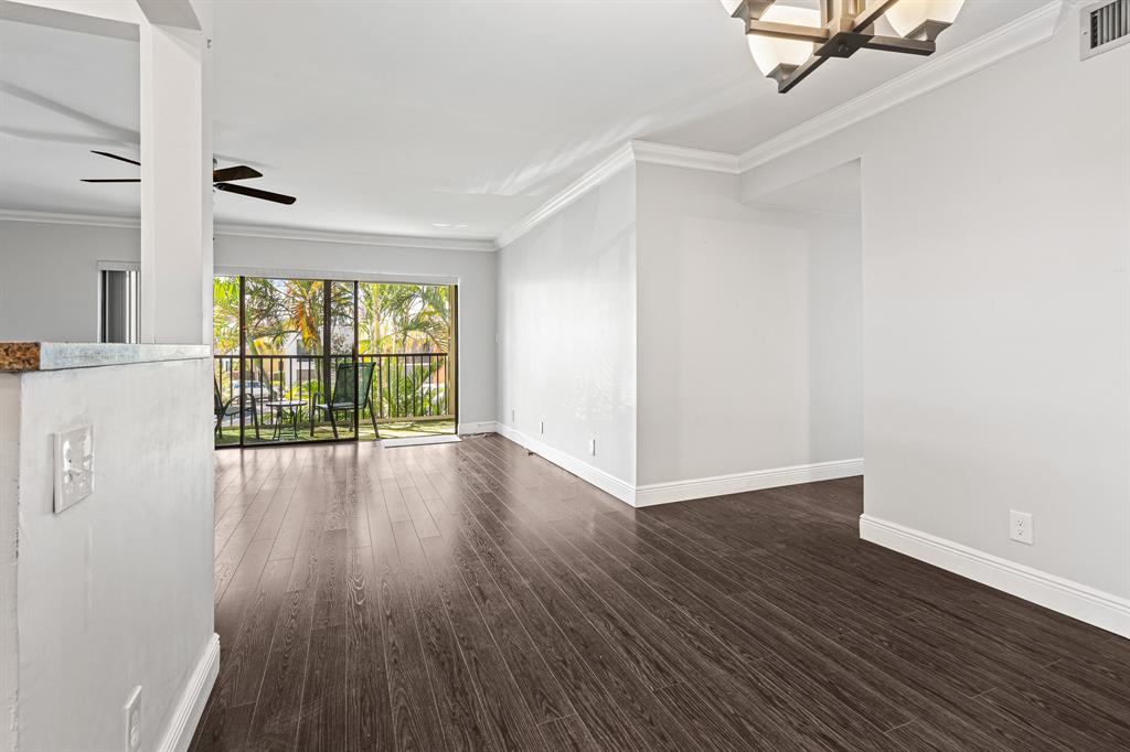 502 Osprey Drive, Unit 17C Delray Beach, FL 33444 - Photo 8 of 41 an empty room with wooden floor and windows
