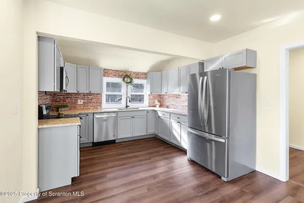 a kitchen with stainless steel appliances a refrigerator and a stove top oven