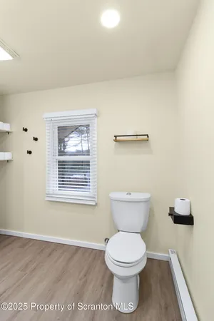 a bathroom with a toilet and a window