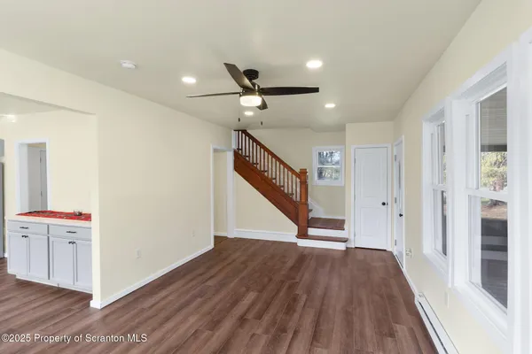 a view of a hallway with wooden floor and staircase
