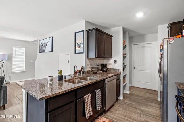 a kitchen with stainless steel appliances granite countertop a sink stove and refrigerator