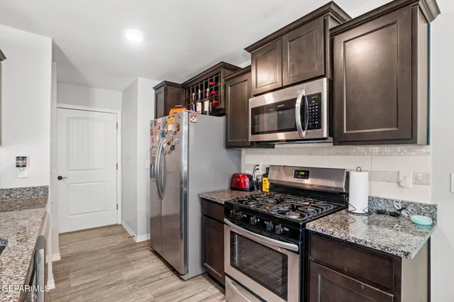 a kitchen with stainless steel appliances granite countertop a stove microwave and refrigerator