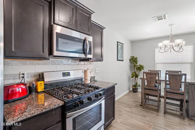a kitchen with microwave stove and wooden floor