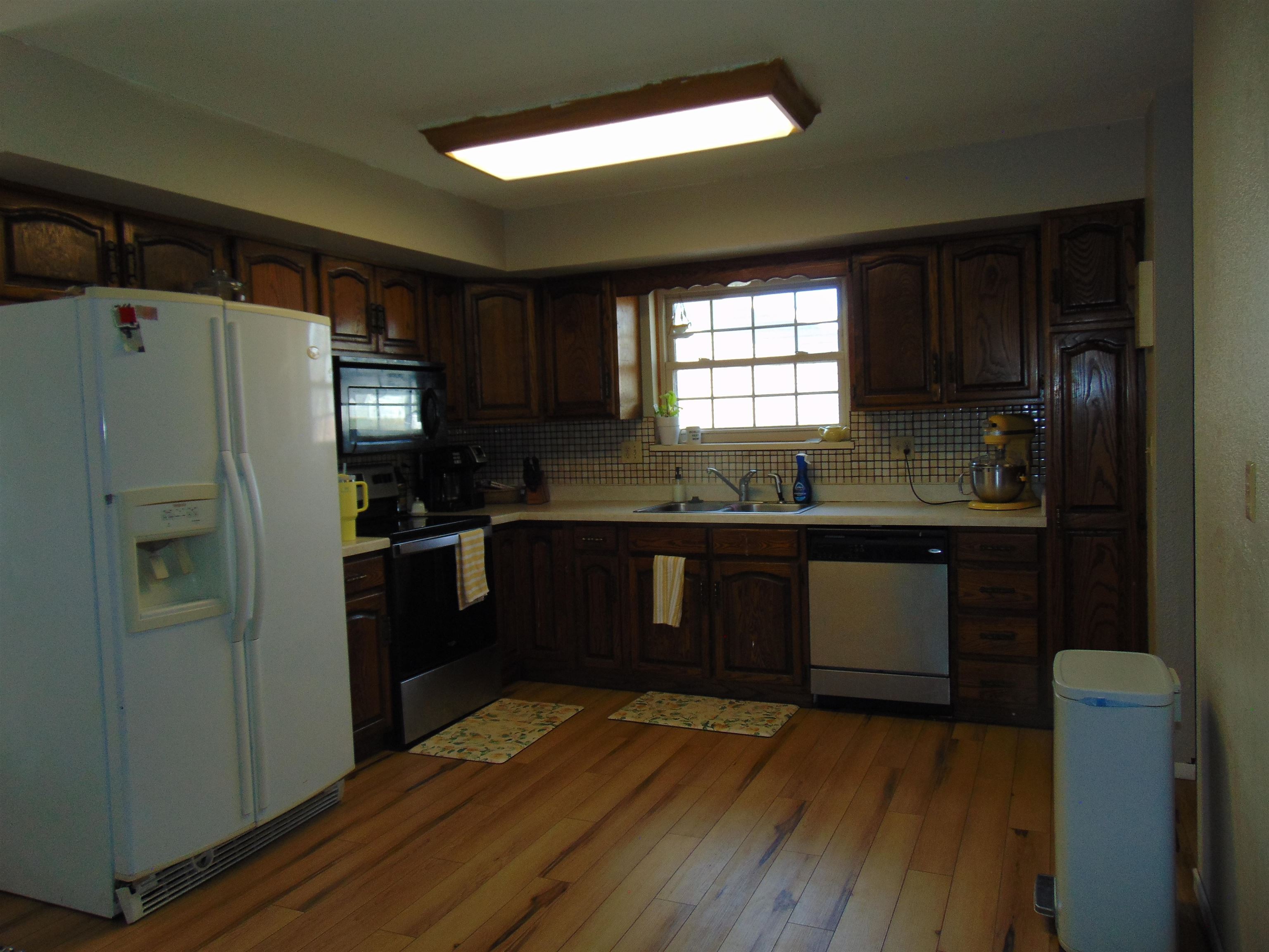 321 North Ash Street Fruita, CO 81521 - Photo 7 of 24 a kitchen with granite countertop a refrigerator and a sink