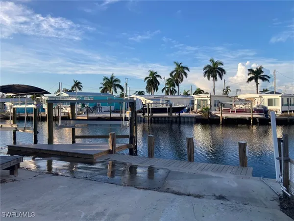 a view of a lake with boats and palm trees