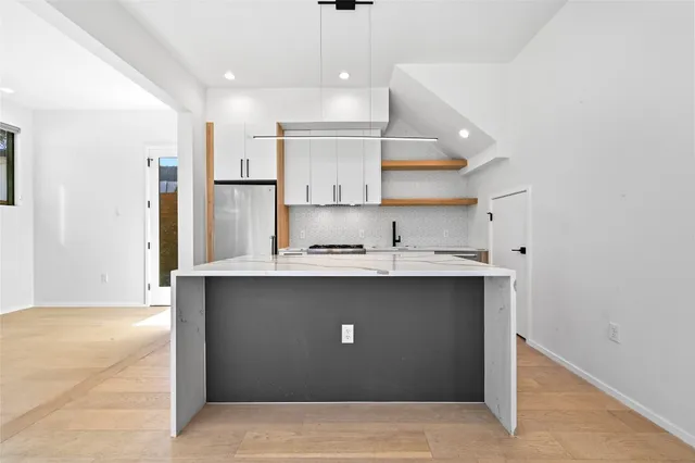a view of kitchen with stainless steel appliances refrigerator stove and kitchen island