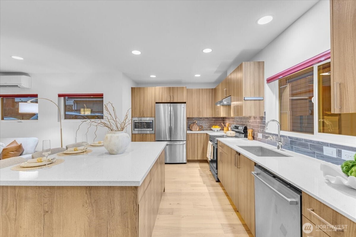 1722 Northwest 60th Street Seattle, WA 98107 - Photo 5 of 37 a kitchen with stainless steel appliances kitchen island granite countertop a sink and cabinets
