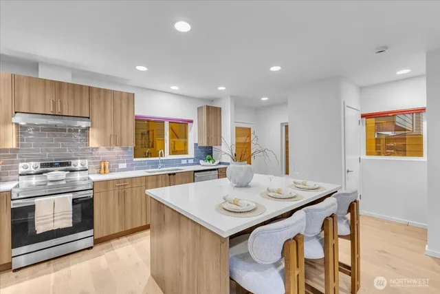 a kitchen with a stove a sink a dining table and chairs