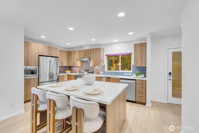 a kitchen with a dining table chairs refrigerator and cabinets