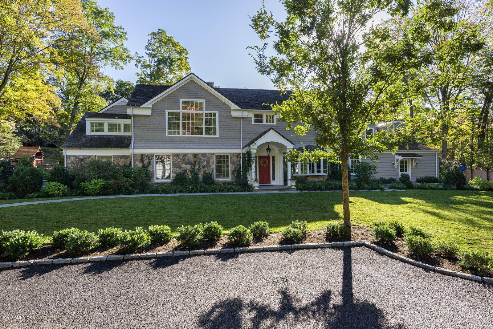 63 Burning Tree Road Greenwich, CT 06830 - Photo 1 of 40 a front view of a house with a yard and garage