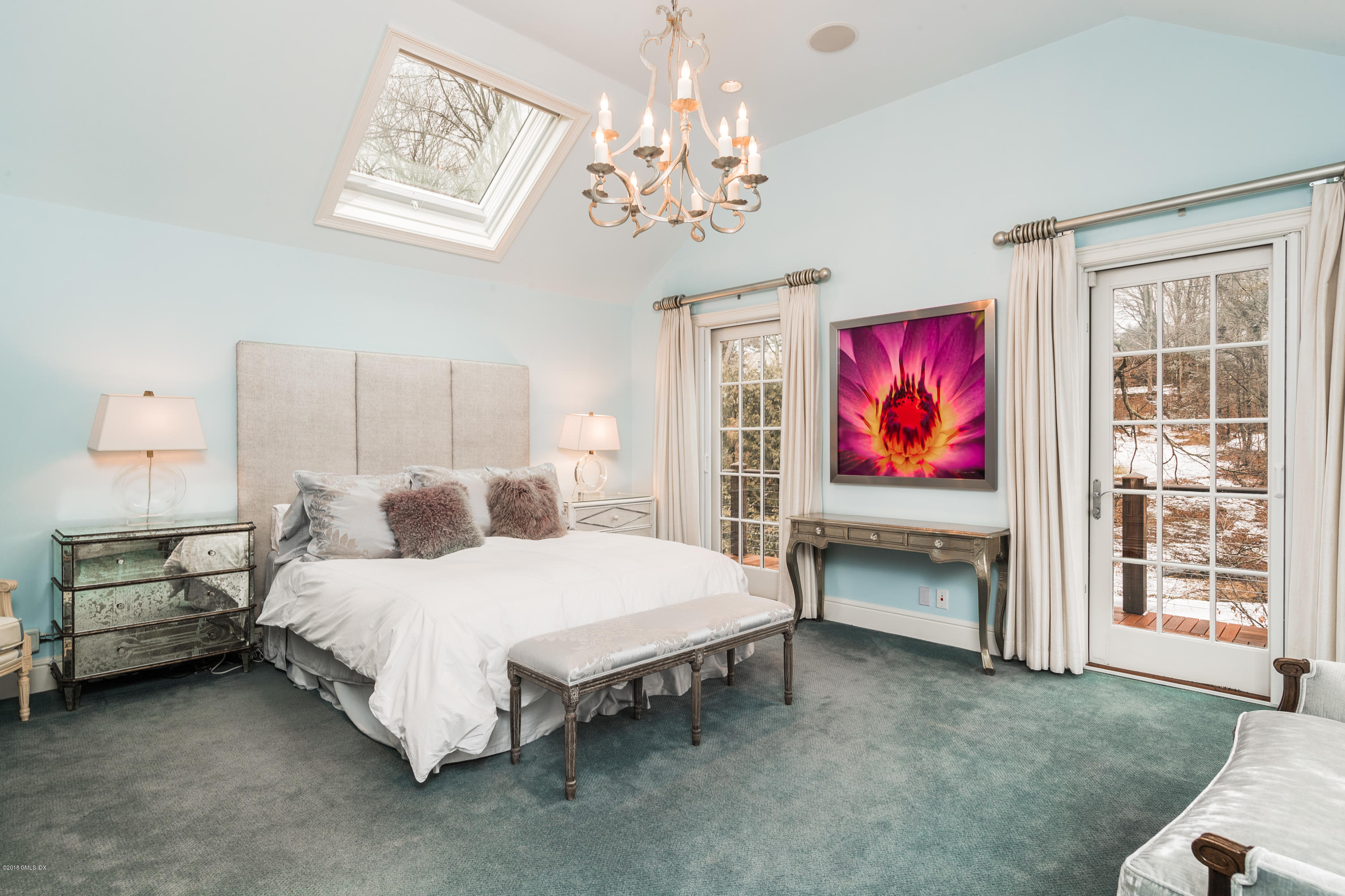 63 Burning Tree Road Greenwich, CT 06830 - Photo 19 of 40 a bedroom with a bed chandelier and window