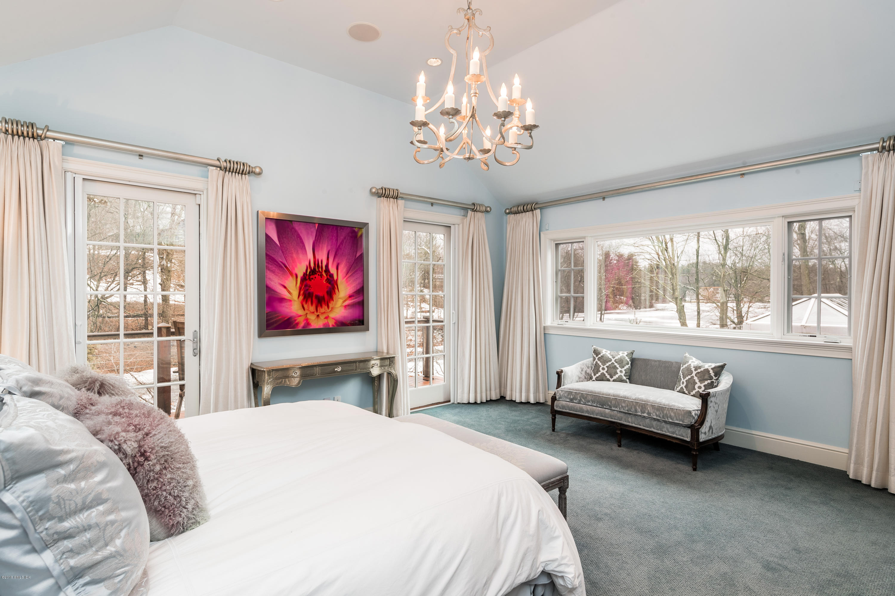 63 Burning Tree Road Greenwich, CT 06830 - Photo 20 of 40 a bedroom with a bed and a chandelier