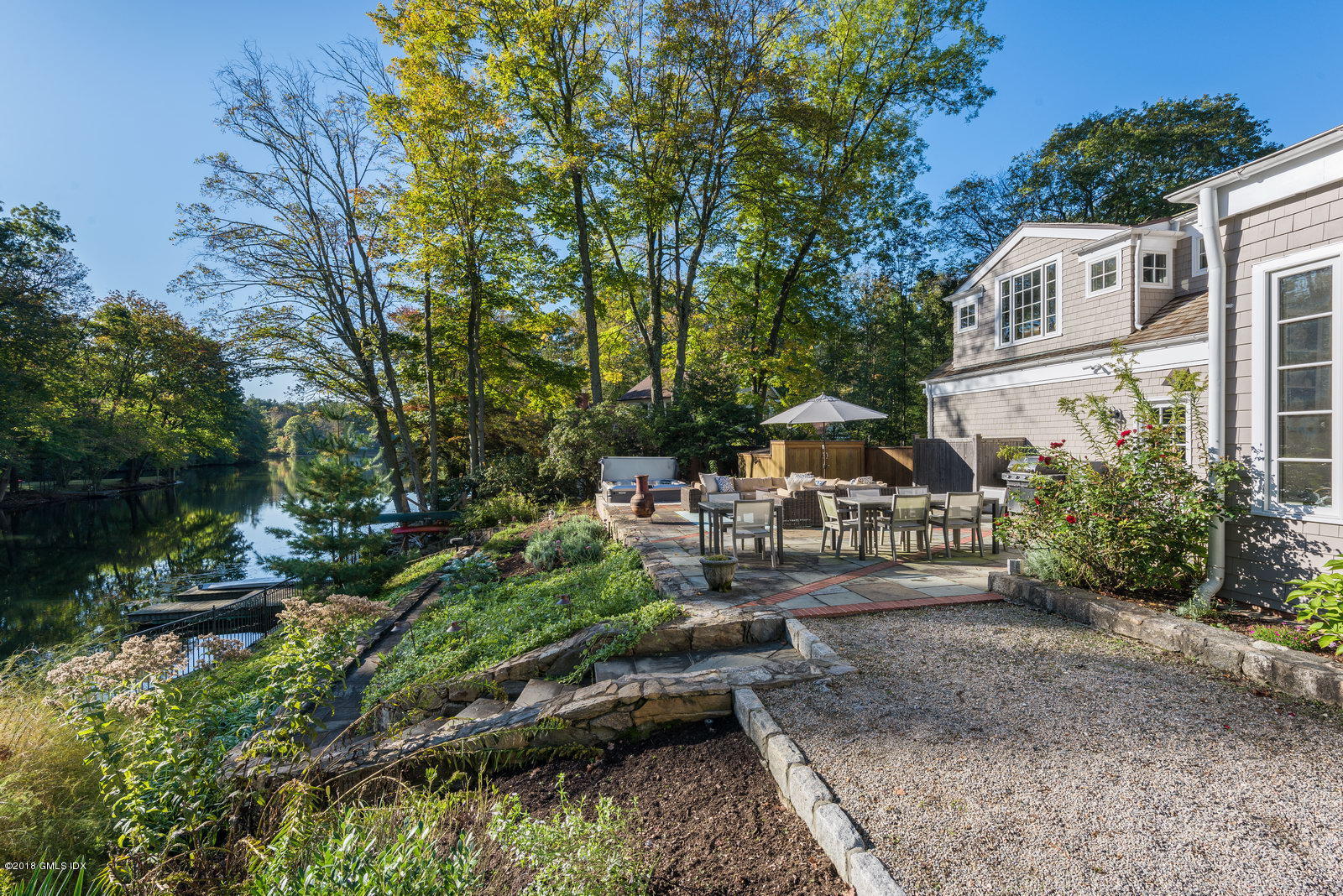 63 Burning Tree Road Greenwich, CT 06830 - Photo 36 of 40 a view of a yard with plants and a bench