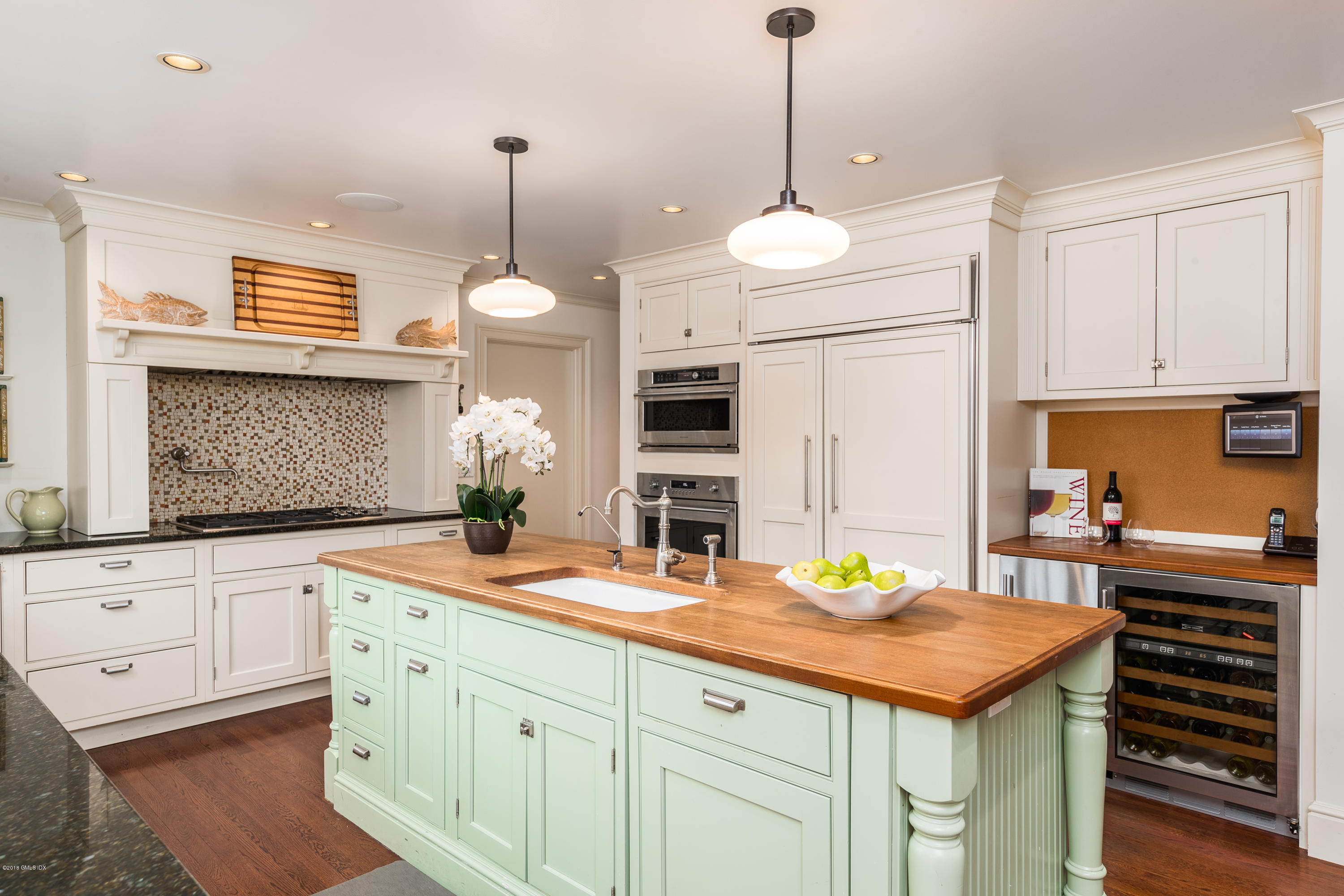 63 Burning Tree Road Greenwich, CT 06830 - Photo 9 of 40 a kitchen with cabinets appliances and a wooden floor