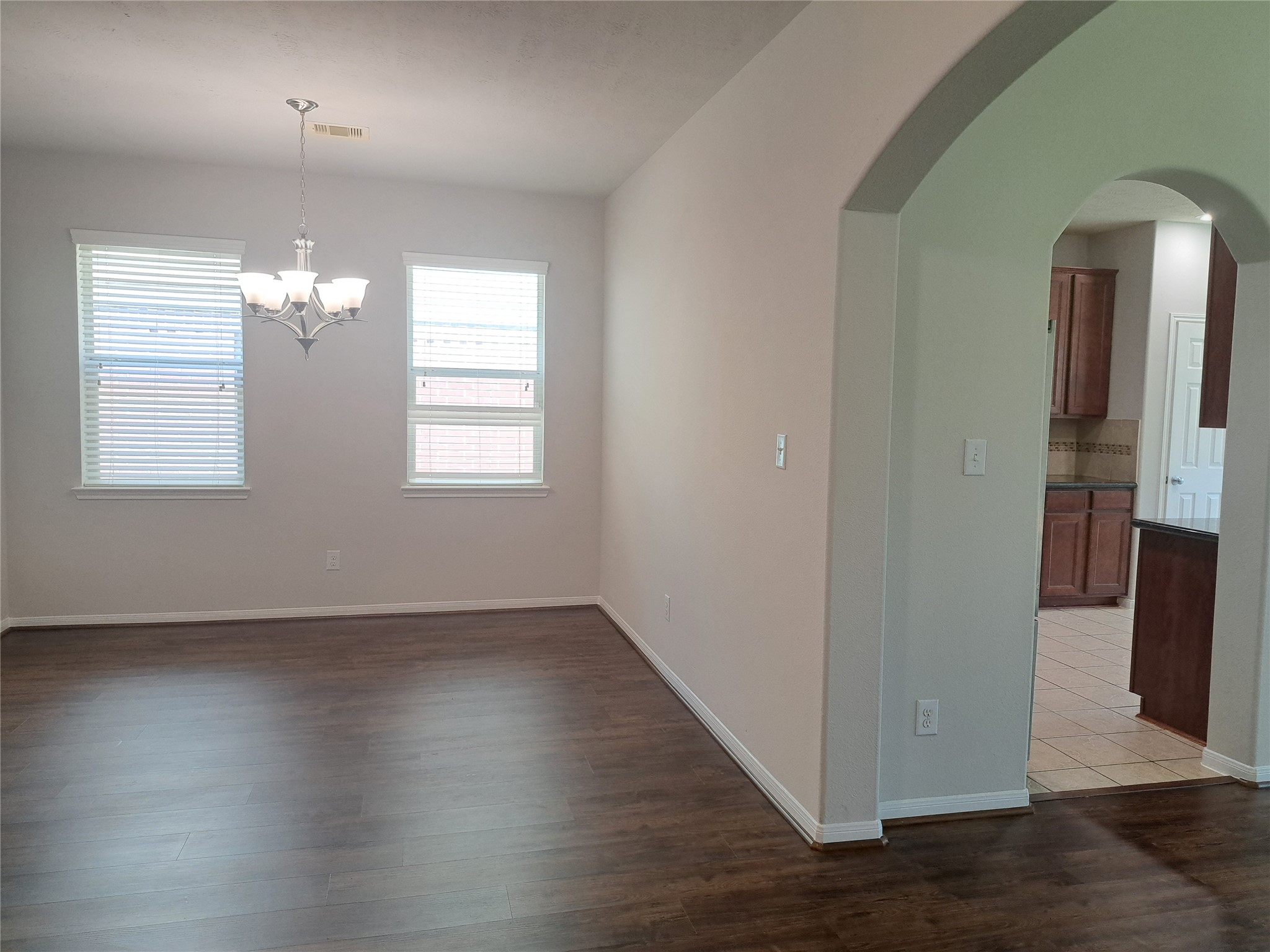 26315 Fox Ridge Lane Katy, TX 77494 - Photo 6 of 39 an empty room with wooden floor chandelier and windows