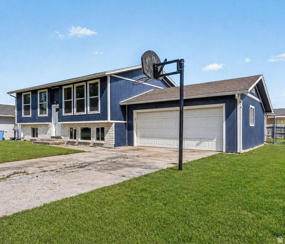 915 Knowles Lane Logan, UT 84321 - Photo 1 of 1 Raised ranch featuring a front yard, concrete driveway, a garage, and brick siding