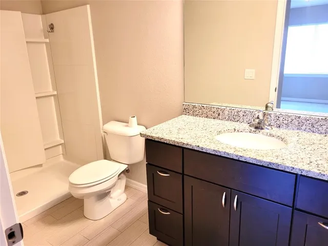 a bathroom with a granite countertop sink toilet and shower
