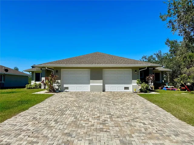 a view of a house with a yard and tree
