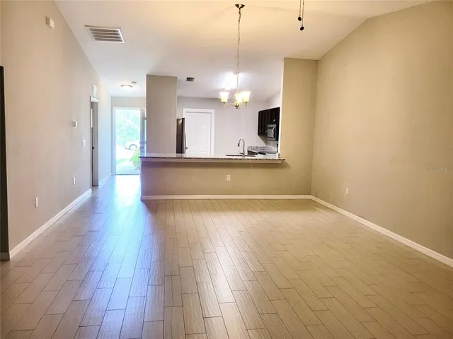 a view of a kitchen with wooden floor and a sink