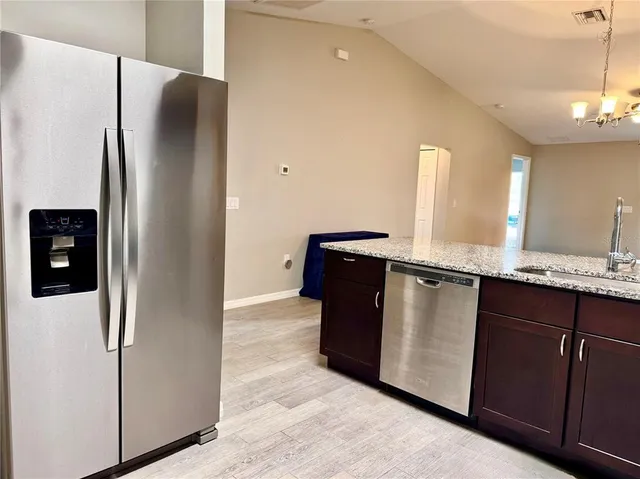 a kitchen with stainless steel appliances granite countertop a refrigerator and a sink