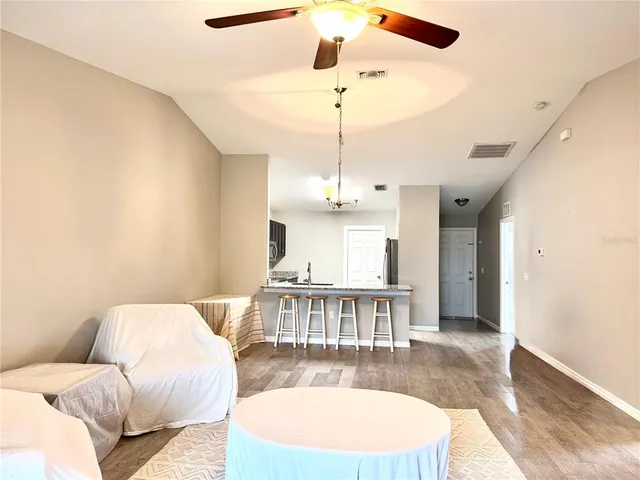 a view of a livingroom with a furniture wooden floor and chandelier