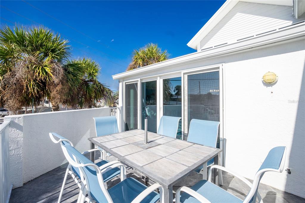 2255 North Beach Road, Unit 13 Englewood, FL 34223 - Photo 16 of 69 a view of a patio with table and chairs with wooden floor and fence