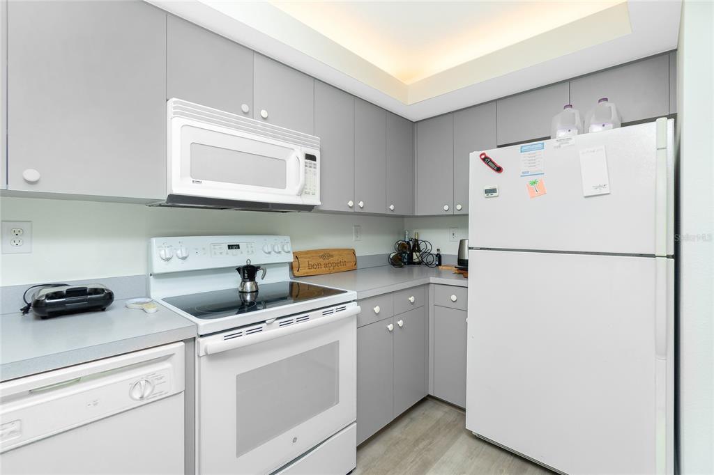 2255 North Beach Road, Unit 13 Englewood, FL 34223 - Photo 22 of 69 a kitchen with a refrigerator a stove a sink and cabinets