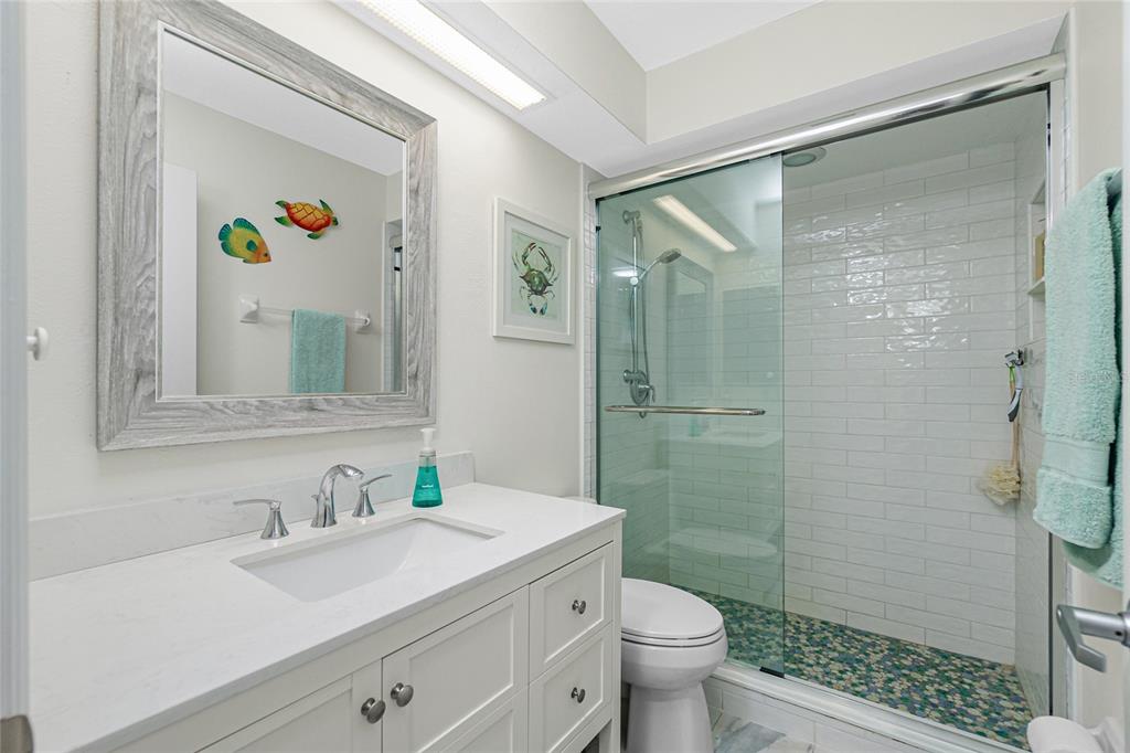 2255 North Beach Road, Unit 13 Englewood, FL 34223 - Photo 33 of 69 a bathroom with a granite countertop sink toilet and shower