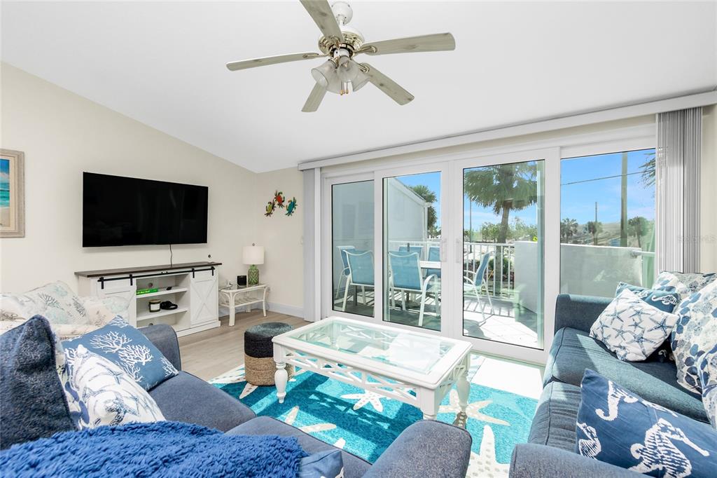 2255 North Beach Road, Unit 13 Englewood, FL 34223 - Photo 10 of 69 a living room with furniture a flat screen tv and a floor to ceiling window