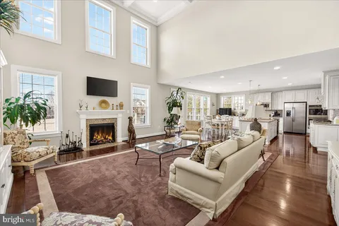 a kitchen with stainless steel appliances granite countertop a stove top oven a sink dishwasher a dining table and chairs with wooden floor