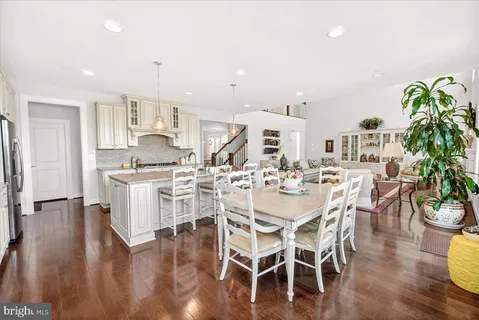 a view of a patio with couches table and chairs with wooden floor and fence