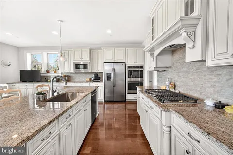 a spacious bedroom with a bed and a flat tv screen on wall
