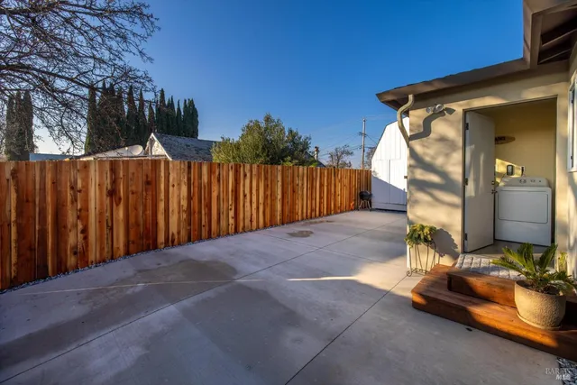 a view of a parked in front of a house with wooden fence