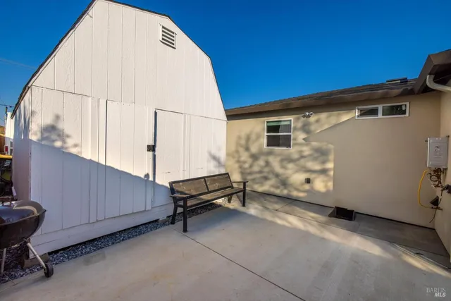 a view of a backyard with wooden fence and trees
