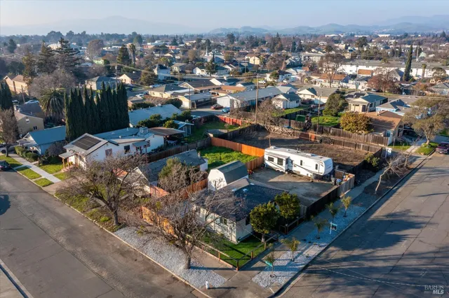 a front view of a house with a garden and tree