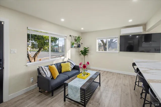 a living room with furniture and a dining table with kitchen view