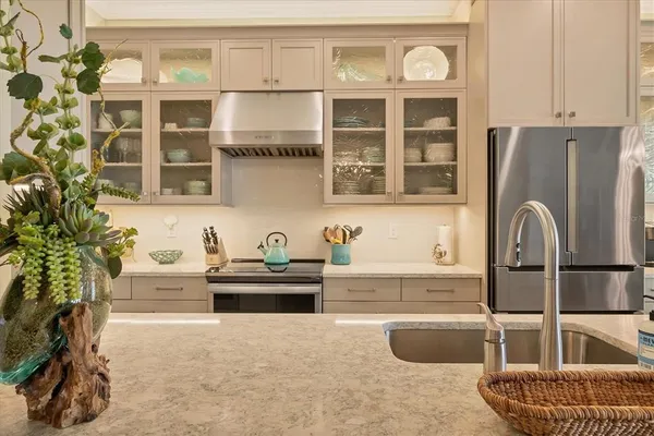 a large kitchen with stainless steel appliances a large center island attached withe living room