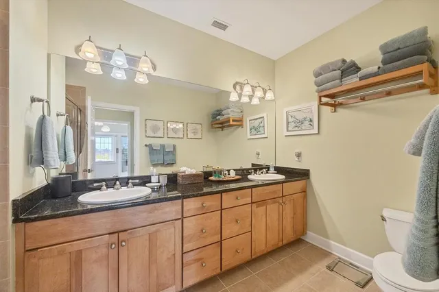 a bathroom with a granite countertop sink a mirror and shower