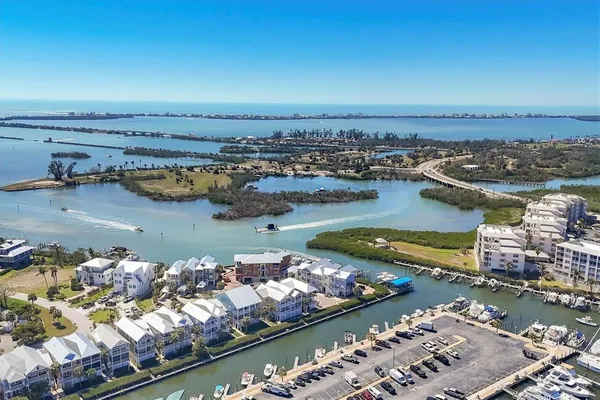 an aerial view of ocean and residential houses with outdoor space