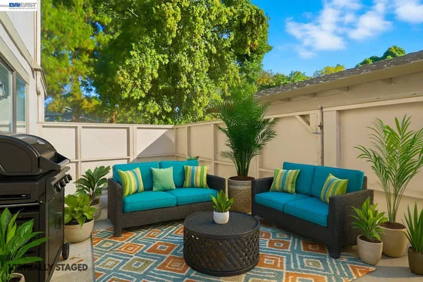 a view of patio with couches table and chairs and potted plants