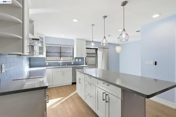 a large kitchen with white cabinets and stainless steel appliances